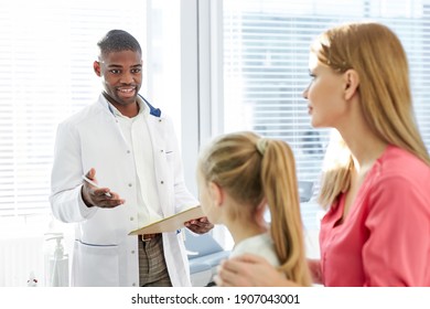 Male Pediatrician Explaining For Sick Child In Hospital Office, Healthcare Physician In Medicine Providing Health Care Services Treatment Examination For Caucasian Patients. Focus On Patients