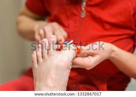 Male pedicure. A pedicure master with gloves holding a man's foot.