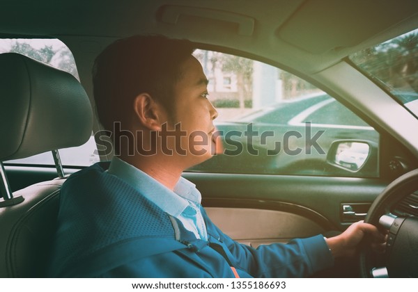 Male person driving his car on the\
road.-Driving to office concept.-Film look\
filter.