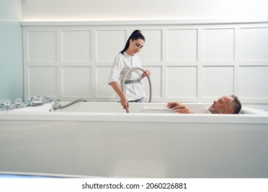 Male person having hydromassage procedure in spa salon