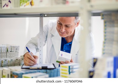 Male pharmacist checking medicines inventory at hospital pharmacy. Pharmacist in drugstore or pharmacy taking notes. Portrait of health care doctor in pharmacy writing on clipboard
 - Powered by Shutterstock