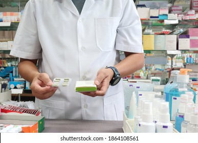 A Male Pharmacist Holding A Medicine Box And Capsule Sachet In A Pharmacy To Check The Drug Correctly Before Delivery To The Customer