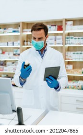 Male Pharmacist With Protective Face Mask Working At Pharmacy. Medical Healthcare Concept.