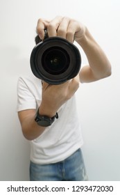 Male Photographer Holding Camera. Wide Angle Perspective Photograph With Lens Blocking Photographer's Face               