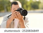 Male photographer with modern camera outdoors