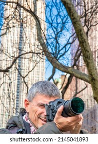 Male Photographer In New York City, Park And Buildings On The Background