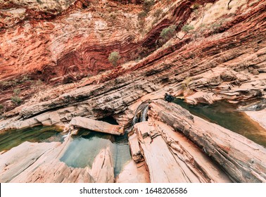 A Male Photographer Shooting Diagonal And Curve Shapes Of Hamersley Gorge, Karijini. This Sacred Aboriginal Site Connected To The Dreamtime Is Also One Of The Ancient Places On Earth. Travel Concept