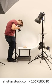 Male Photographer In Studio Shooting Food On Plate