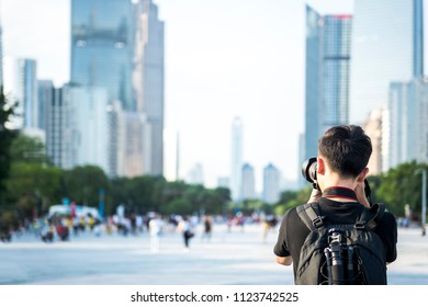 A Male Photographer Takes A Backpack And Camera To Photograph The City.