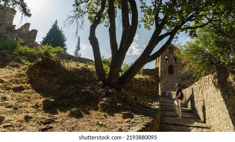 Male Photographer Taking Pictures Of Ancient City Of Mystras, Sparta. UNESCO World Heritage Archeological Sight.