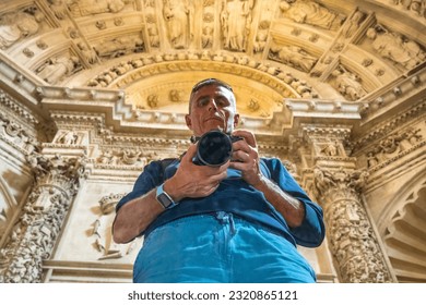 Male photographer taking pictures inside Seville Cathedral.