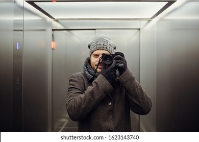 Male Photographer Taking A Self Picture In An Elevator. Mirror Selfie Portrait, Learning Photography And Analog Film Look Concept.