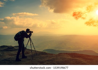 A male photographer travels and shoots landscapes at sunset - Powered by Shutterstock