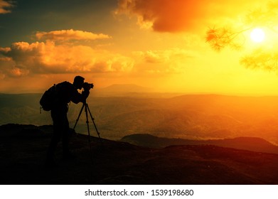 A male photographer travels and shoots landscapes at sunset - Powered by Shutterstock