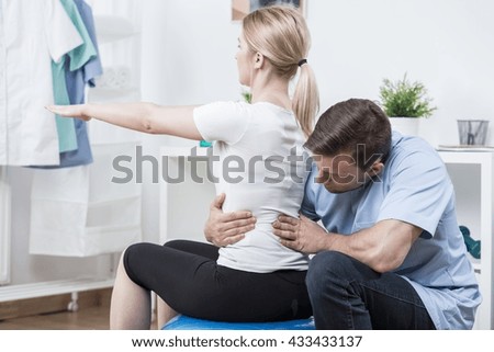 Male physical therapist doing spinal column manipulation