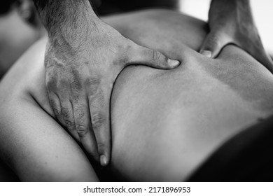 Male Physical Therapist Massaging Female Client’s Back Muscle.