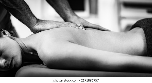 Male Physical Therapist Massaging Female Client’s Back Muscle.