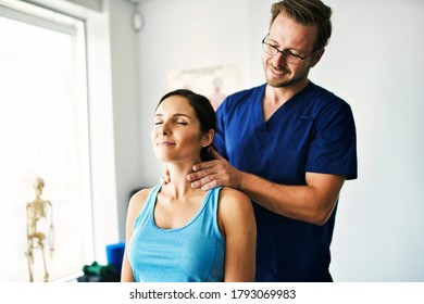 A Male Physical Therapist Stretching A Female Patient Neck