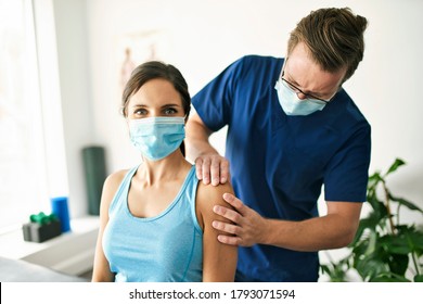 A Male Physical Therapist Stretching A Female Patient Slowly.