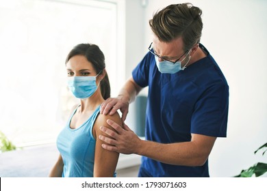 A Male Physical Therapist Stretching A Female Patient Slowly.