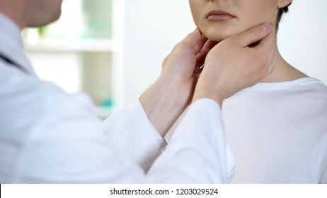 Male physician checking patient throat and neck, health examination in hospital - Powered by Shutterstock