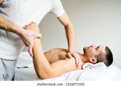 Male physio therapist giving sport massage to the young Man at the salon - Powered by Shutterstock