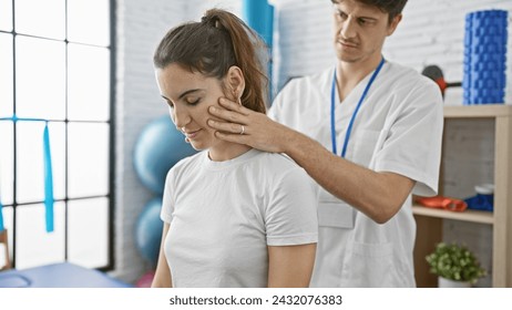 A male physiotherapist assesses a woman's neck in a modern physiotherapy clinic. - Powered by Shutterstock