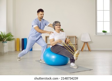 Male Physiotherapist Do Exercises Workout With Elderly Woman Patient In Physio Medical Clinic. Therapist Doctor Help Old Grandmother Recover After Injury Or Trauma. Mature Rehabilitation.