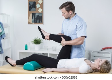 Male physiotherapist exercising with patient having knee pain - Powered by Shutterstock