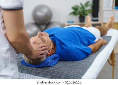 Male physiotherapist giving head massage a senior patient in clinic - Powered by Shutterstock