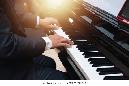 Male pianist hands on grand piano keyboard. Hands of a person playing piano.Concept of music recording, rehearsal or live performance. - Powered by Shutterstock