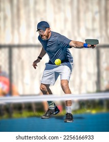 Male pickleball player slices ball with a backhand shot - Shutterstock ID 2256166933