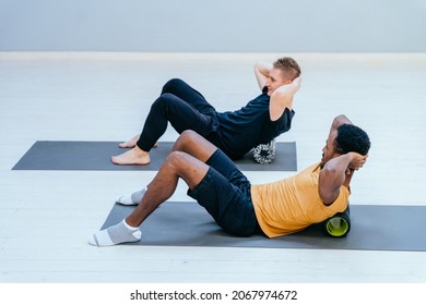 Male Pilates Trainer Nad African American Man, Individual Training Participant, Do Perform Correctly. Exercise With Foam Roller, Class In Sport Studio Led By Experienced Instructor Concept.