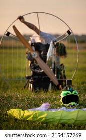 A male pilot is preparing a paralet with a gasoline engine for flights. Selective Focus on the pilot's helmet with a fixed video camera. Paragliding for individual paragliding flights. Extreme sports.