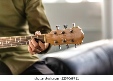 Male is playing guitar outdoors. Closeup image of musician hand holding strings. - Shutterstock ID 2257069711