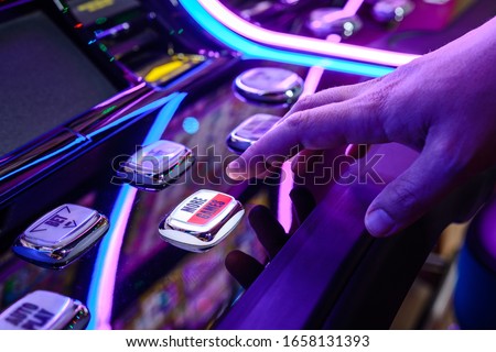 Male Playing Slot Machines In Casino. Close-up Of Male Hand