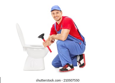 Male plumber sitting next to a toilet and holding a plunger isolated on white background