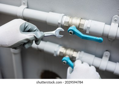 Male Plumber Worker Installation Pipe System Use Wrench With The Water Tap. Plumbing Checking Service And Repair.