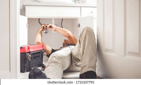Handreparierrosa-Rohrleitung für männliche Klempner mit verstellbarem Schlüssel
.Klempner Mann mit Werkzeugen im Badezimmer. Anlage und Renovierung