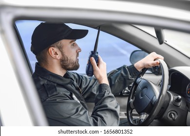 Male police officer driving car - Powered by Shutterstock