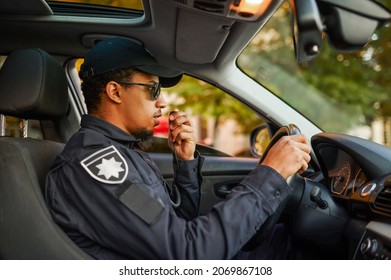 Male Police Officer Talking On A Walkie-talkie