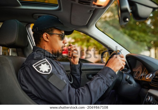 Male police\
officer talking on a\
walkie-talkie