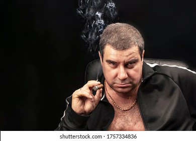 male portrait, a man Smoking a cigar. thug, experienced criminal Smoking a cigar sitting on a chair. Russian mafia.   copy space, black and gloomy background