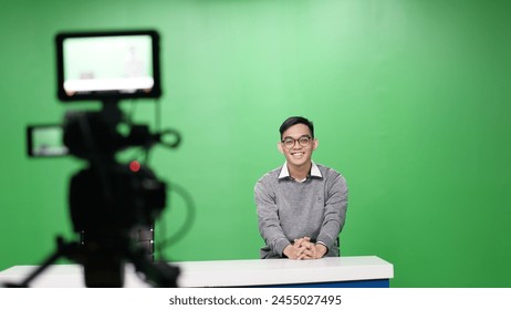 Male presenter sitting chairs in front of camera on green screen - Powered by Shutterstock