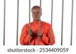 male prisoner in handcuffs behind bars