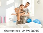 Male professional chiropractor or physical therapist working with Caucasian man