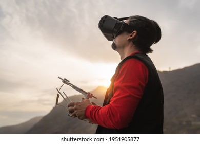 Male professional drone pilot doing fpv experience with virtual reality glasses during sunset time - Technology and innovation concept