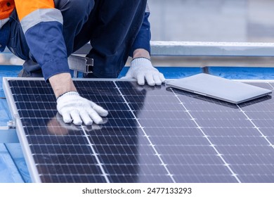Male professional engineer installing solar photovoltaic panel system, Electrician, worker mounting blue solar module technology on power industrial factory roof, Alternative energy, renewable energy.