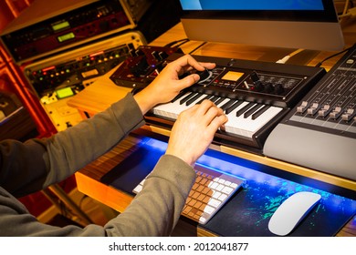 Male Professional Music Producer Hands Arranging A Hit Song On Keyboard And Computer In Home Studio. Music Production Concept