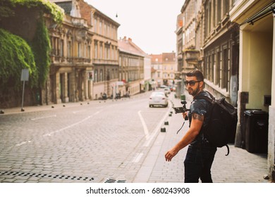 Male professional videographer travel photographer making video in 4K resolution trough the streets of Zagreb holding 3 axis gimbal stabilizer.Filming with stabilized camera.Travel light equipment
